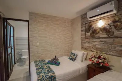 a hotel room with two beds and a television at Villa Indalia in Seminyak