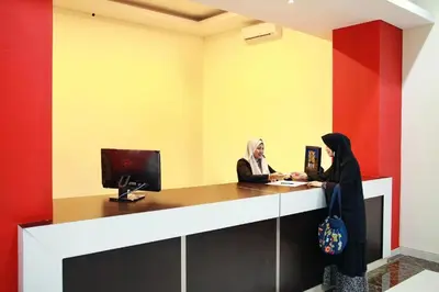 two women in hijab standing at a reception desk at Alkyfa Hotel Bali in Denpasar
