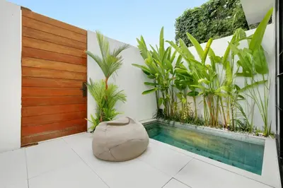 a swimming pool in the middle of a balcony with plants at The Oasis Smart Villa in Canggu