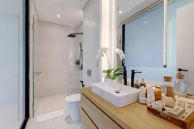 a bathroom with a white sink and a toilet at The Oasis Smart Villa in Canggu