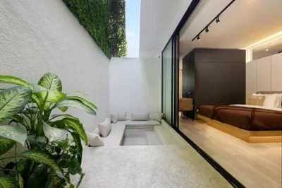 a bedroom with a bed and plants at The Oasis Smart Villa in Canggu