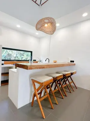 a kitchen with a counter with stools around it at Stella Moon Villa Bali in Kerobokan