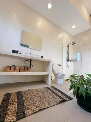 a bathroom with a shower and a toilet and a rug at Stella Moon Villa Bali in Kerobokan