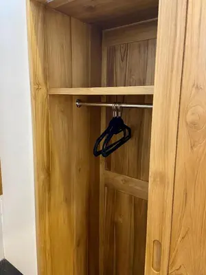 a wooden door with a hanger in a closet at Villa Solas Legian in Legian