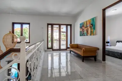 a bedroom with a balcony with a bed and a couch at Villa Sky View - Seminyak in Seminyak