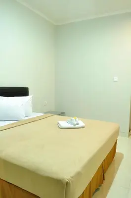 a bed with a towel sitting on top of it at Amerta Home Stay Bali in Denpasar