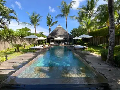 a pool at a resort with palm trees and umbrellas at Villa Samuan in Seminyak
