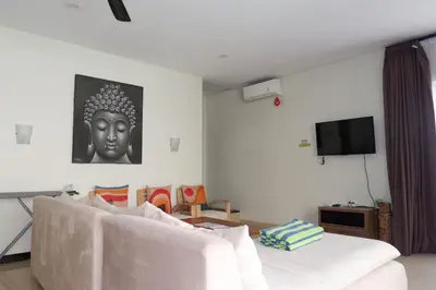 a living room with a white couch and a tv at The BALIem Villa in Jimbaran