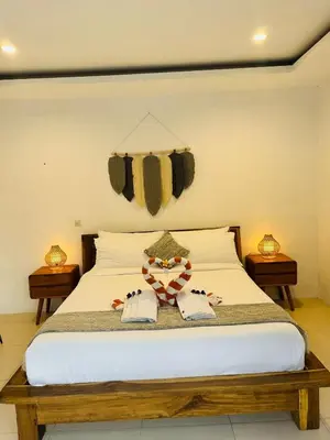 a bedroom with a bed with two towels on it at De'Huta Villa in Canggu