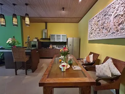 a kitchen and living room with a wooden table at The Chand Villa - A Hidden Gem in Petitenget in Seminyak