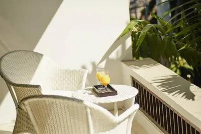 a table with a drink and two chairs on a balcony at Yoga Villa in Seminyak