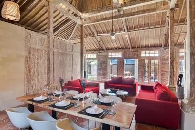 a living room with a table and red couches at Selog Villa 2 in Seminyak