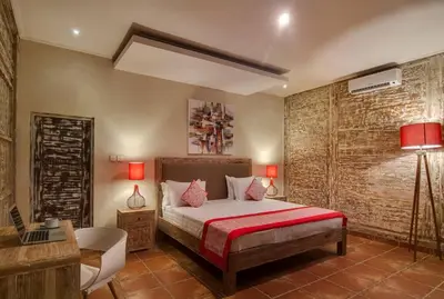 a bedroom with a bed and a desk and a laptop at Selog Villa 2 in Seminyak