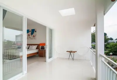 a white room with a bed and chairs on a balcony at Selog Villa 4 in Seminyak