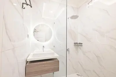 a white bathroom with a sink and a mirror at Desa Residence Kerobokan in Kerobokan