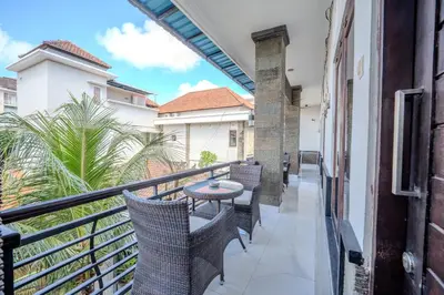 a balcony with chairs and a table on it at Wana Kubu Homestay in Kuta