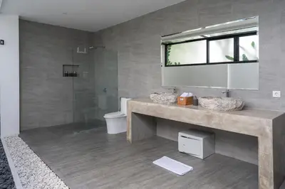 a bathroom with a sink and a toilet and a mirror at LOTUS - Bali Invest Club in Kerobokan