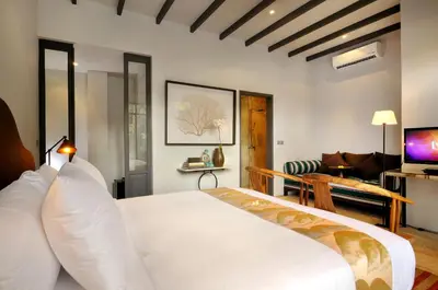 a bedroom with a white bed and a living room at Room & Vespa 1 - Stay Central Seminyak Near Beach in Seminyak
