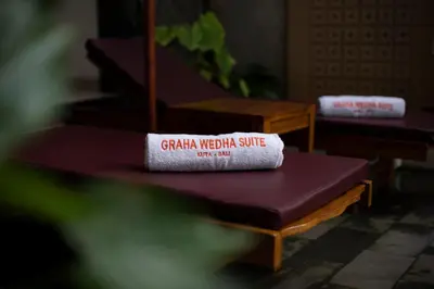 a book sitting on top of a purple bench at Graha Wedha Suite Kuta by kamara in Kuta