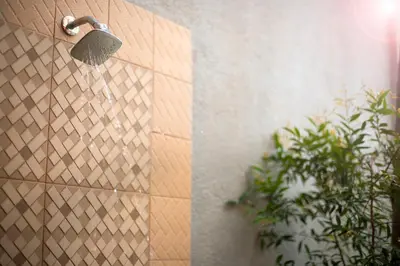 a shower head with water coming out of it at Graha Wedha Suite Kuta by kamara in Kuta