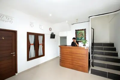 a woman standing at a counter in a room at Graha Wedha Suite Kuta by kamara in Kuta