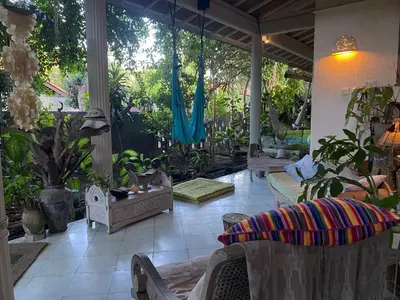 a patio with chairs and plants in a yard at Shady Grove Healing Centre & Homestay w house rules please read before booking in Sanur