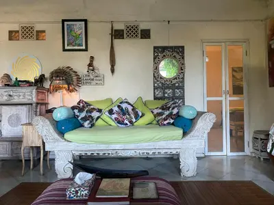 a couch with pillows in a living room at Shady Grove Healing Centre & Homestay w house rules please read before booking in Sanur
