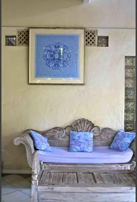 a couch with blue pillows sitting in a room at Shady Grove Healing Centre & Homestay w house rules please read before booking in Sanur