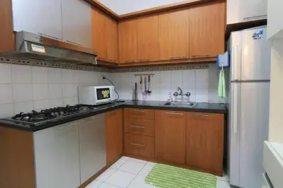 a kitchen with wooden cabinets and a stove top oven at kuta 5BR private villa pool ,near airport, in Kuta