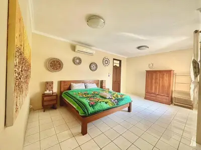 a bedroom with a bed with a green comforter at kuta 5BR private villa pool ,near airport, in Kuta