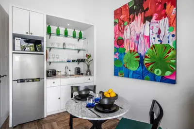 a kitchen with a table and a painting on the wall at Villa Balik II Seminyak in Seminyak