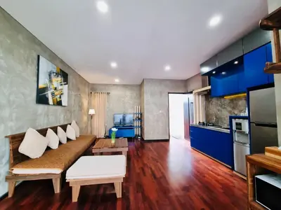 a living room with a couch and a kitchen at Bali 3BR Family Nicho House in Seminyak