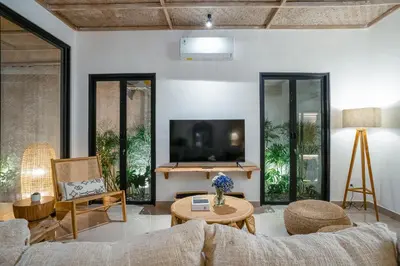 a living room with a couch and a tv at Villa Aarna - Tropical Chic Private Oasis in Seminyak in Seminyak