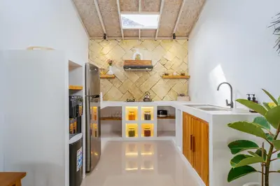 a kitchen with white counters and yellow cabinets at Villa Aarna - Tropical Chic Private Oasis in Seminyak in Seminyak
