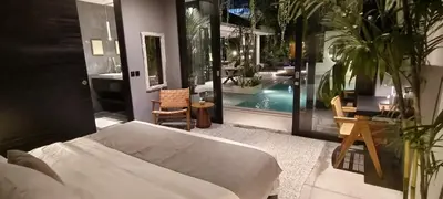 a bedroom with a bed and a swimming pool at Villa Naura Umalas in Dalung
