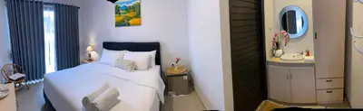 a bedroom with a bed with a sink and a mirror at Queen’s Villa in Seminyak
