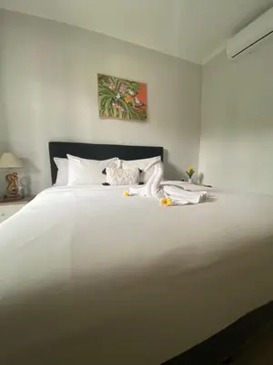 a white bed with white sheets and pillows at Queen’s Villa in Seminyak