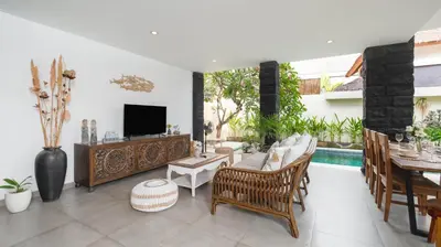 a living room with a couch and a tv at Villa Ambalika by Villa Finder in Seminyak