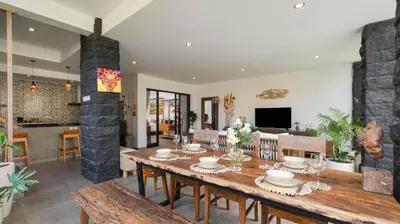 a dining room with a wooden table and chairs at Villa Ambalika by Villa Finder in Seminyak