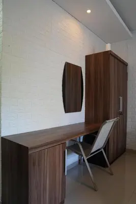 a wooden desk with a chair in a room at Doris Seminyak Studio in Seminyak