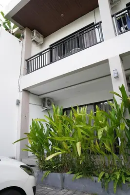 a white house with plants in front of it at Doris Seminyak Studio in Seminyak