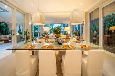a dining room with a large glass table and white chairs at Villa Sunsara 4 - Enchanting 4BR Villa in a Great Location in Canggu