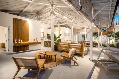 a room with wooden chairs and tables in a building at Villa Surga Julie by Alfred in Bali in Seminyak