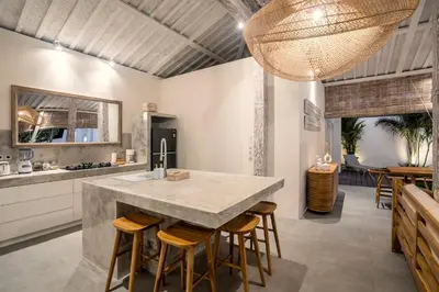 a kitchen with a large island with bar stools at Villa Surga Julie by Alfred in Bali in Seminyak