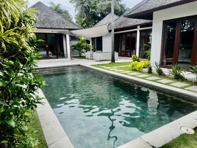 a swimming pool in front of a house at Villa Iris in Dalung