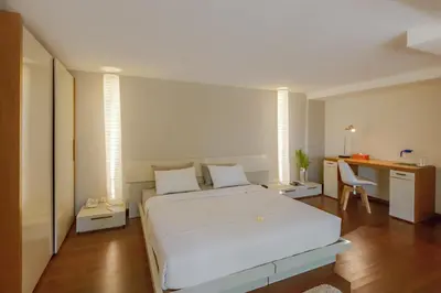 a bedroom with a white bed and a desk at Petitenget 501 in Seminyak