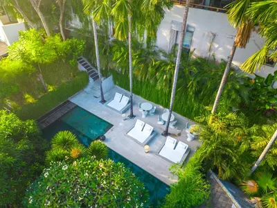 an overhead view of a pool with chairs and palm trees at Petitenget 501 in Seminyak