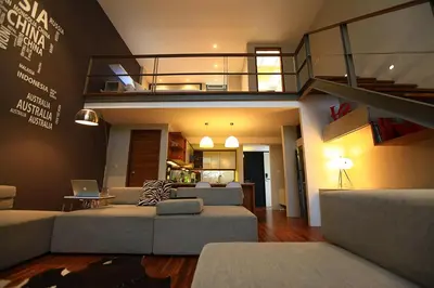 a living room with two couches and a staircase at Petitenget 501 in Seminyak