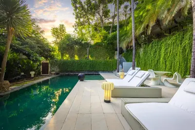 a swimming pool with white lounge chairs and a swimming pool at Petitenget 501 in Seminyak
