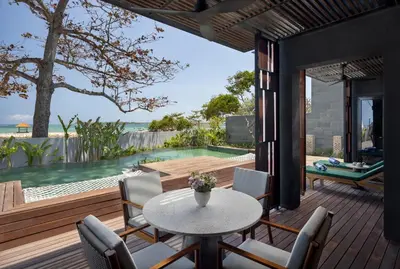 a patio with a table and chairs and a pool at Sumitra Luxury Villas & Resort by Pramana in Sanur